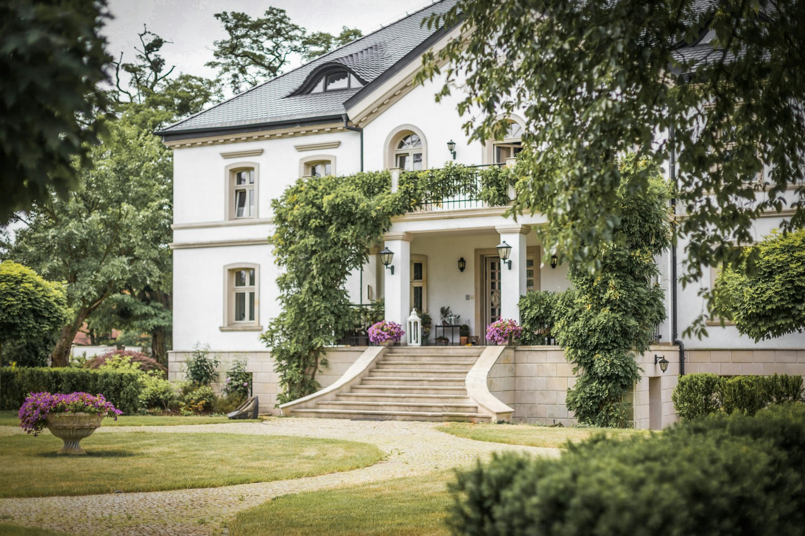 white concrete house near green trees during daytime